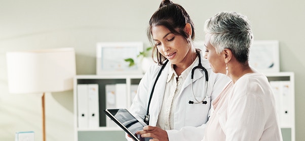 Female doctor conversing with female patient.