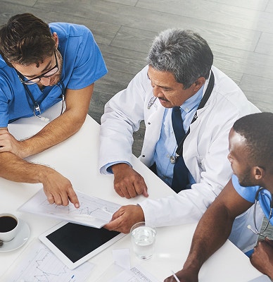 Three male doctors conversing.