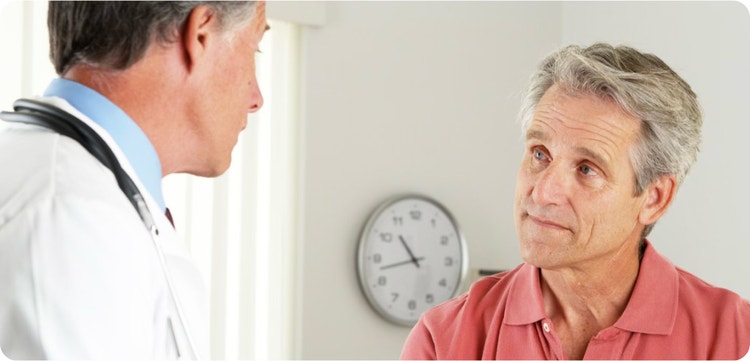Male doctor conversing with a male patient.