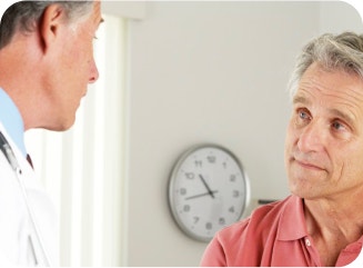 Male doctor conversing with a male patient.