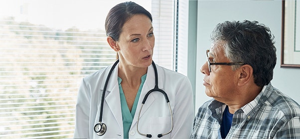 Female doctor conversing with male patient.